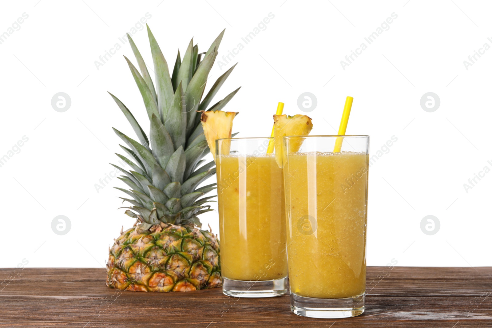 Photo of Tasty pineapple smoothie and cut fruit on wooden table against white background