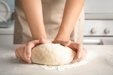 Photo of Woman kneading dough for pastry on table