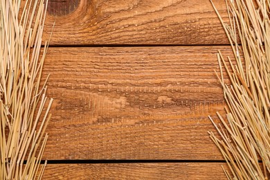 Dried hay on wooden background, flat lay. Space for text