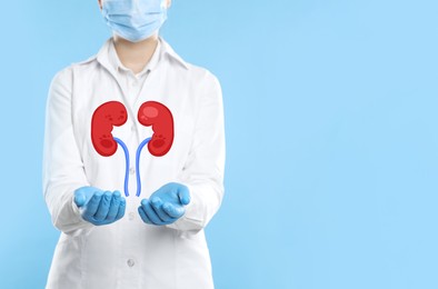 Closeup view of doctor and illustration of kidneys on light blue background. Space for text