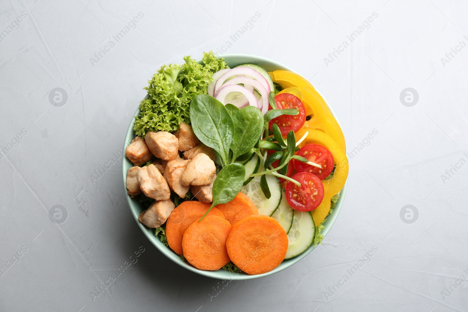 Photo of Delicious fresh chicken salad served on grey table, top view