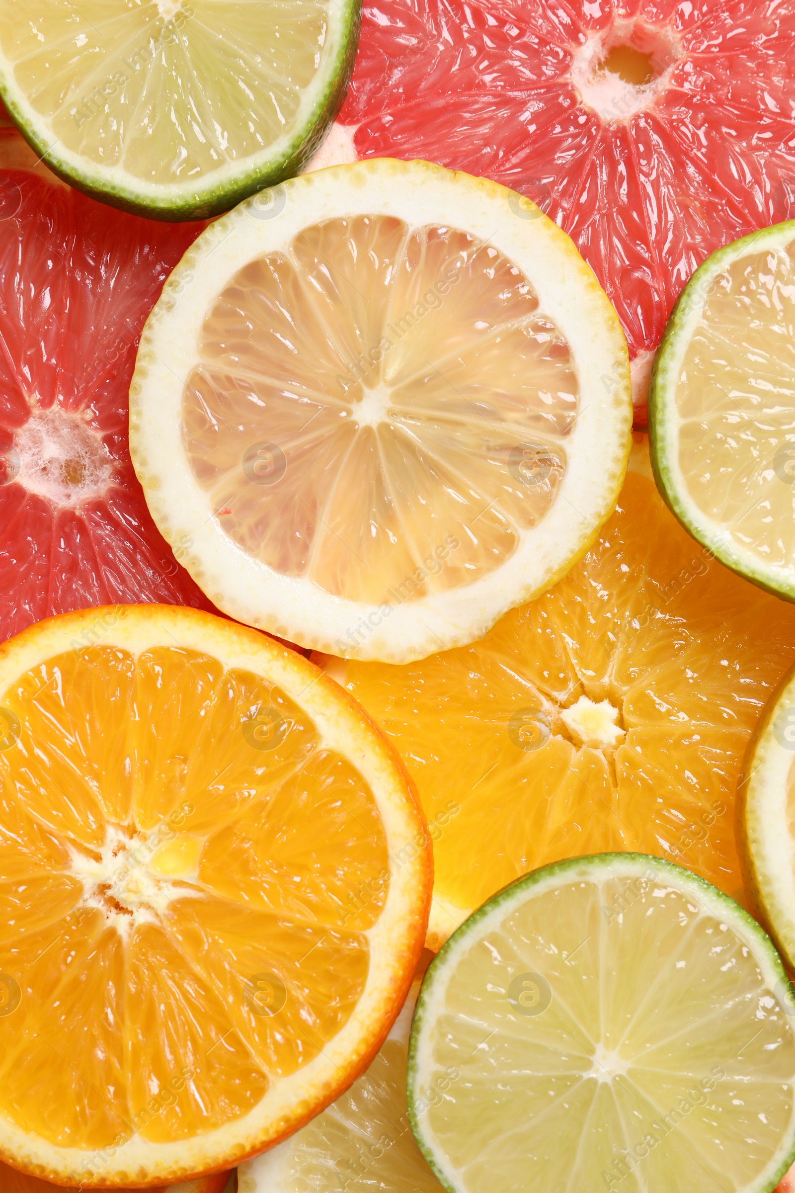 Photo of Different sliced citrus fruits as background, top view