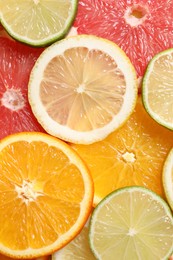 Different sliced citrus fruits as background, top view