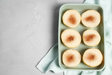 Photo of Flat lay composition with sliced fresh ripe pears, cinnamon and space for text on gray background