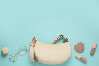 Photo of Flat lay composition with stylish baguette handbag on light blue background. Space for text