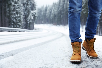 Photo of Man walking outdoors on snowy winter day. Space for text