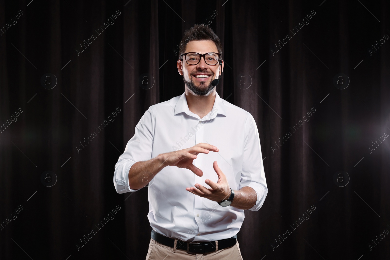 Photo of Motivational speaker with headset performing on stage