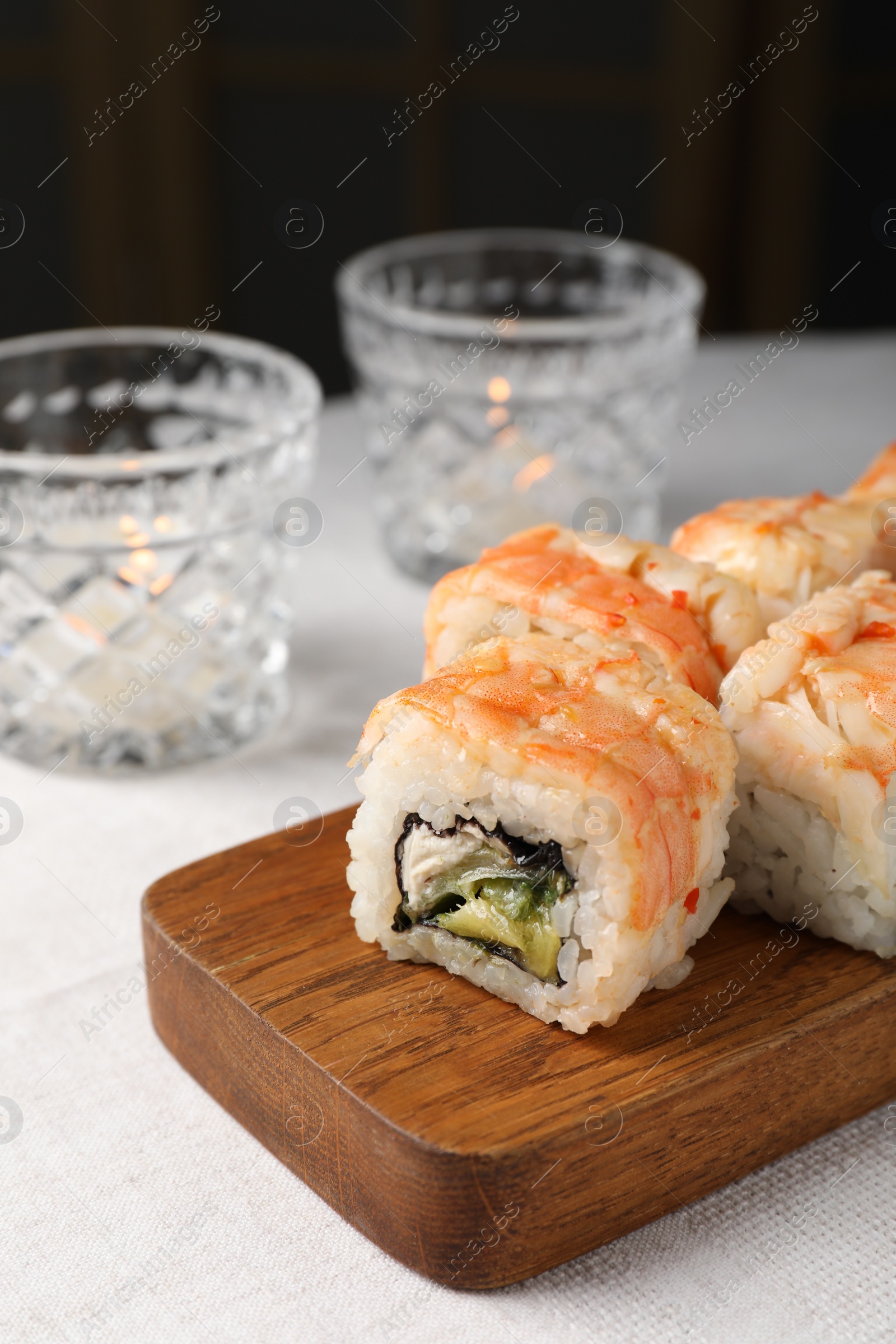 Photo of Delicious sushi rolls with shrimps served on white table