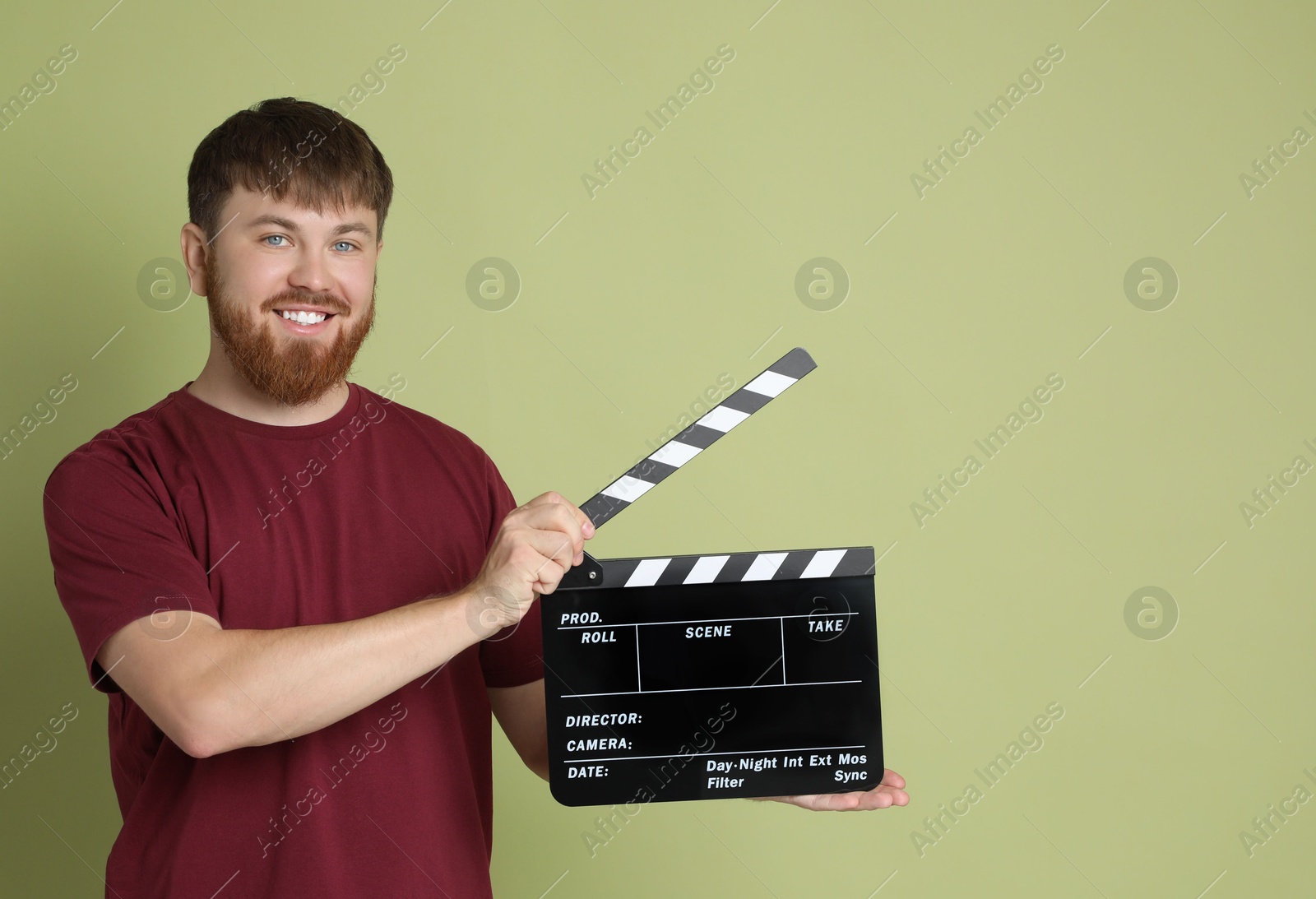 Photo of Making movie. Smiling man with clapperboard on green background. Space for text