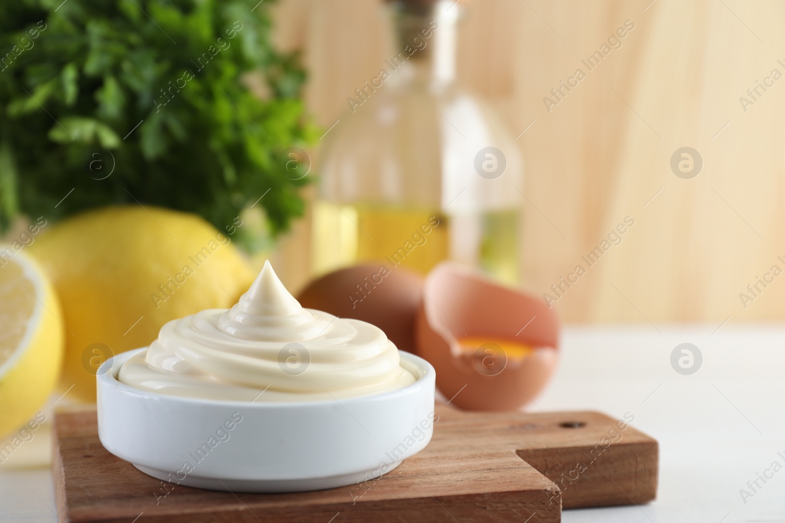 Photo of Fresh mayonnaise sauce in bowl on white table, space for text