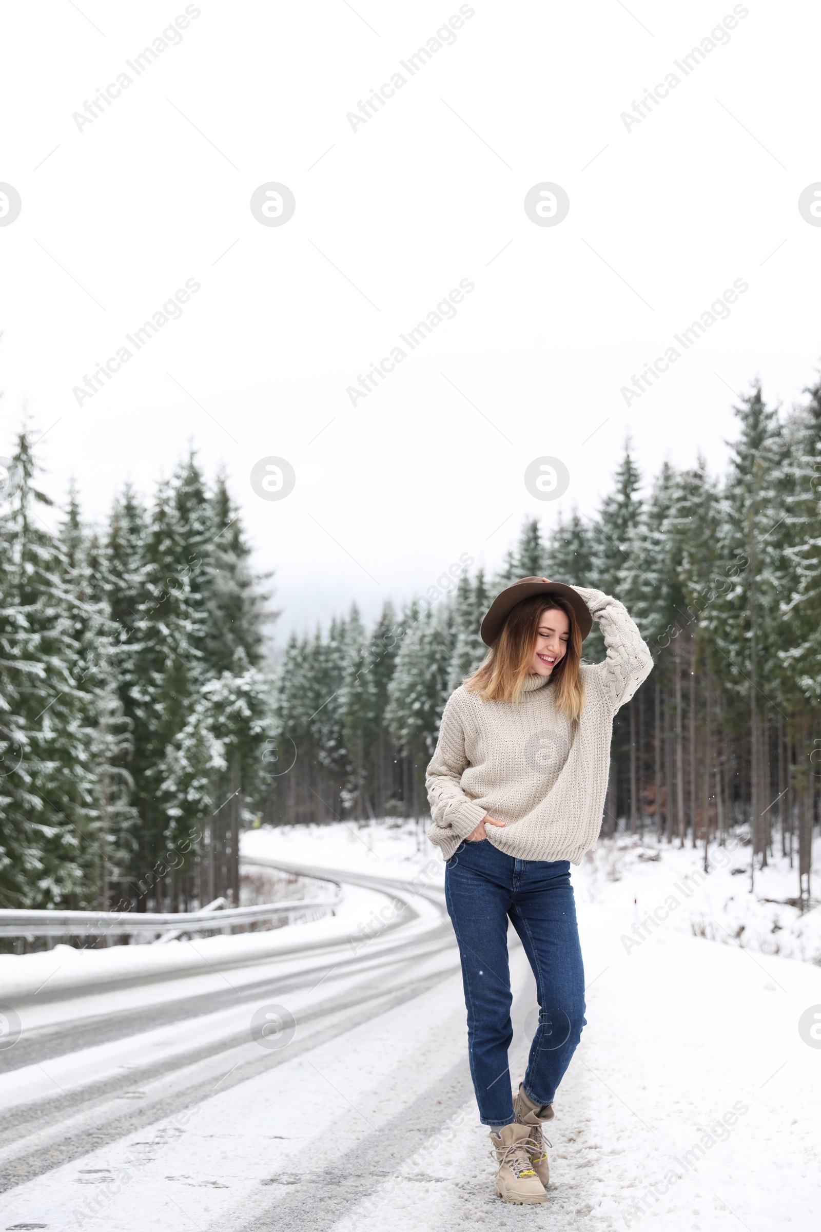 Photo of Young woman walking near snowy forest. Winter vacation