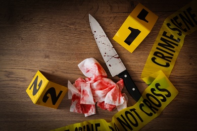 Flat lay composition with evidences and crime scene markers on wooden background