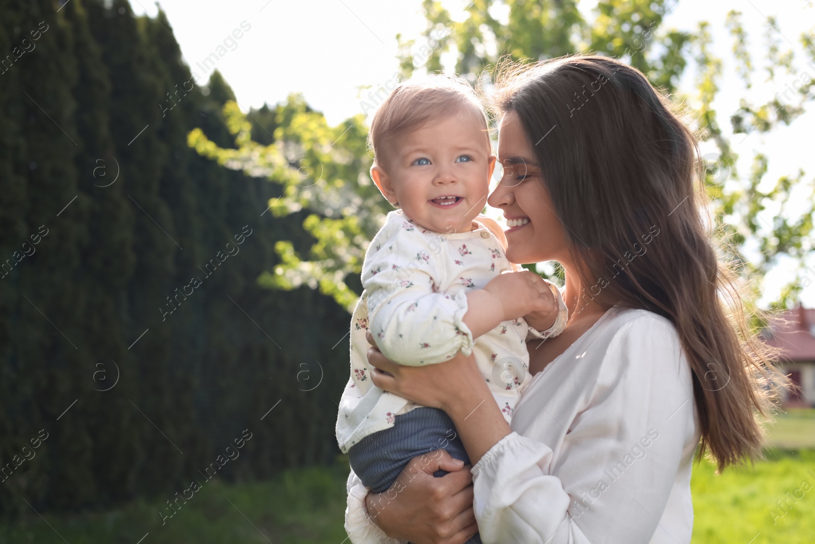 Photo of Happy mother with her cute baby in park on sunny day, space for text