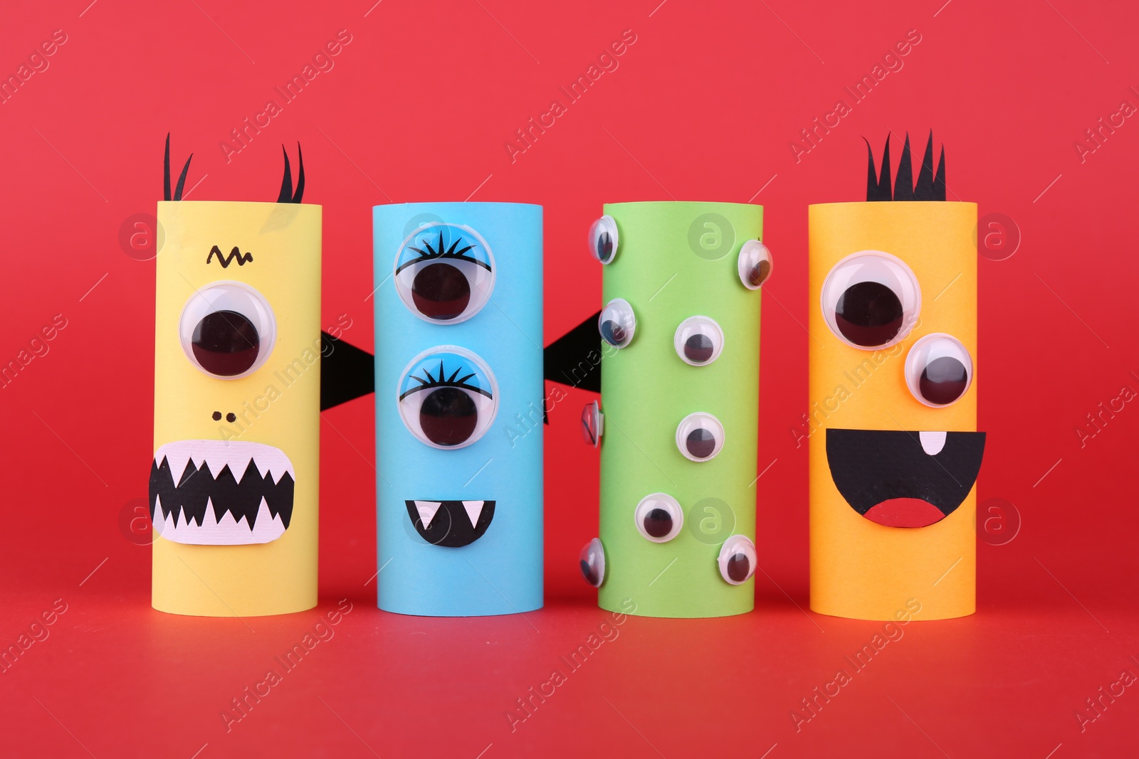 Photo of Spooky paper monsters on red background. Handmade Halloween decoration