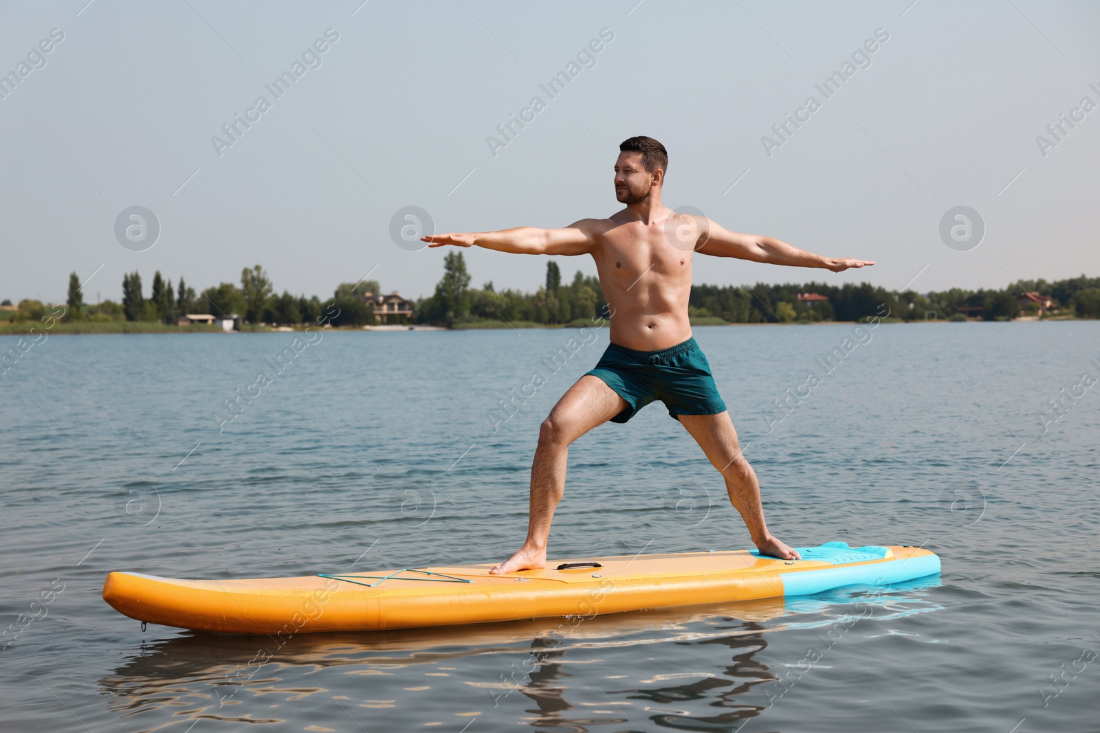 Photo of Man practicing yoga on SUP board on river