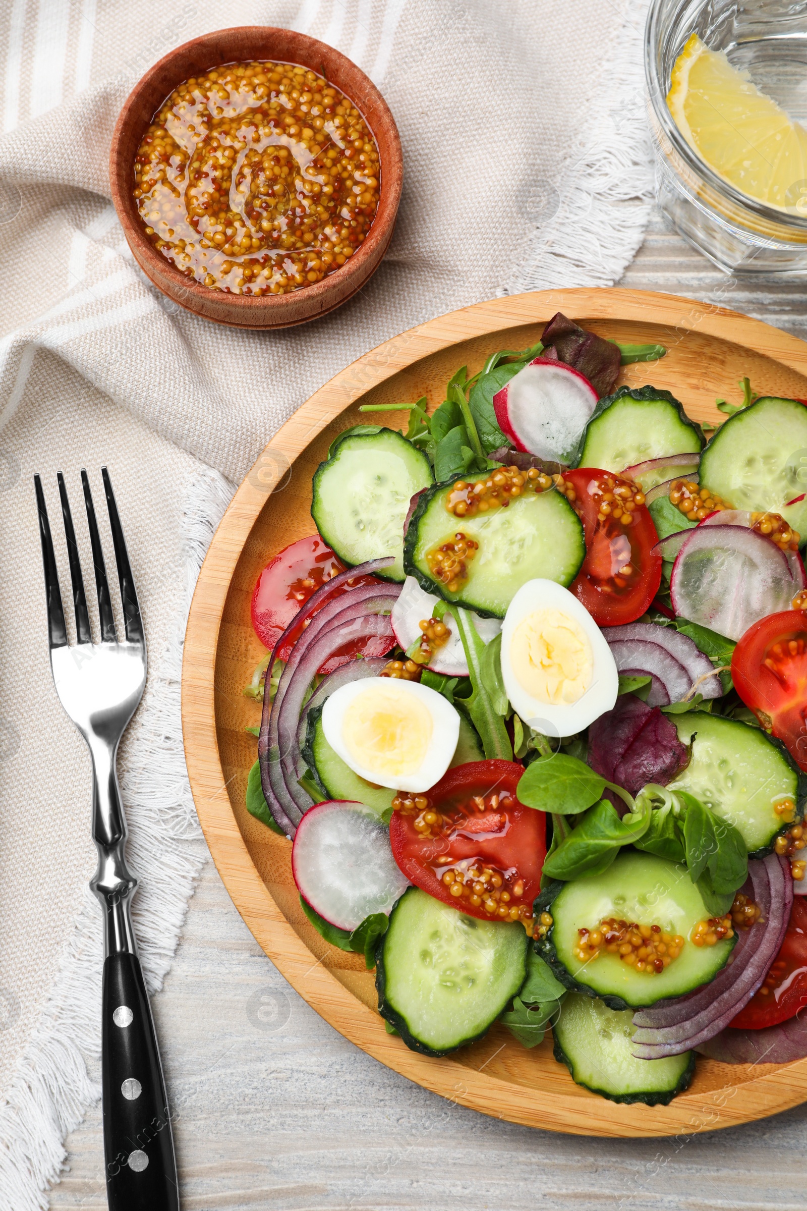 Photo of Tasty salad with vegetables and quail eggs on wooden table, flat lay