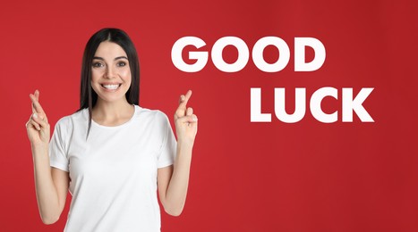 Image of Woman with crossed fingers on red background. Good luck superstition