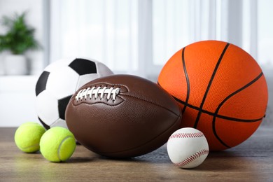 Photo of Set of different sport balls on wooden table indoors