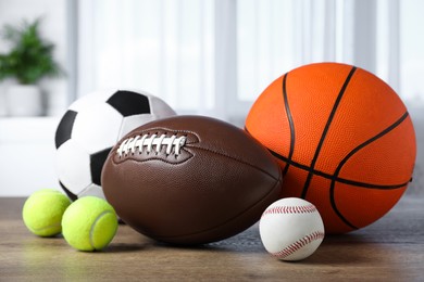 Set of different sport balls on wooden table indoors