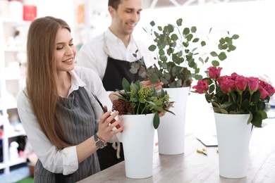 Young florists making beautiful bouquet in flower shop