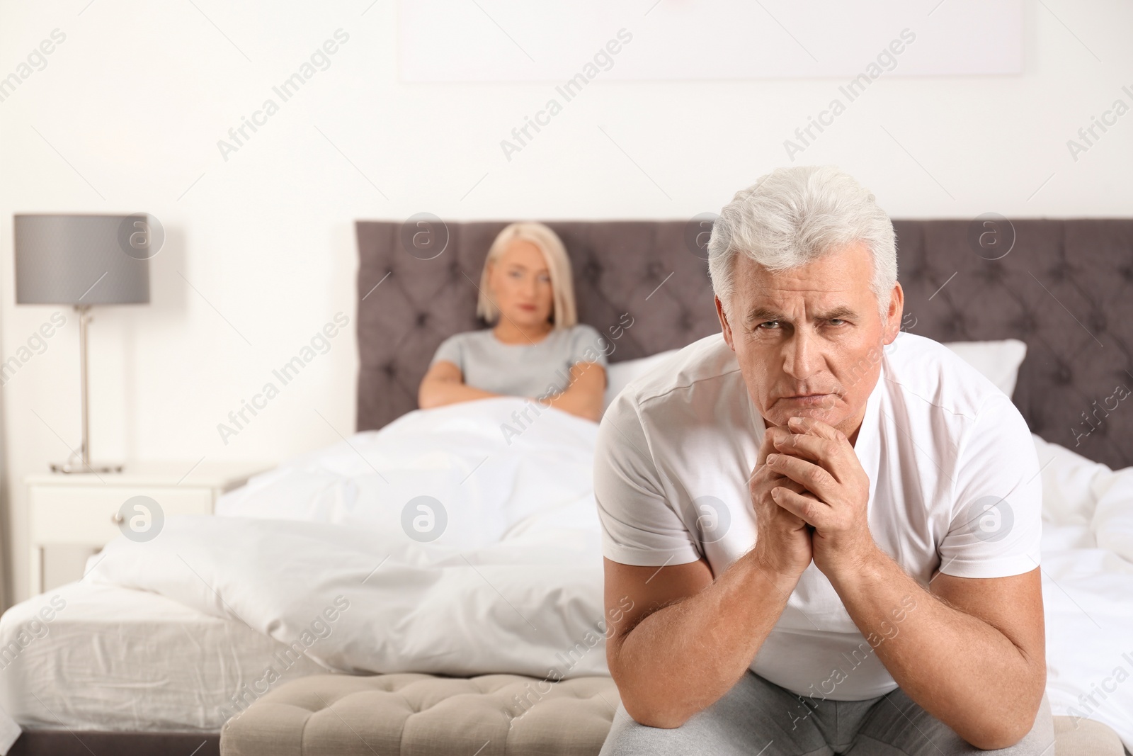 Photo of Senior man having conflict with his wife in bedroom. Relationship problems