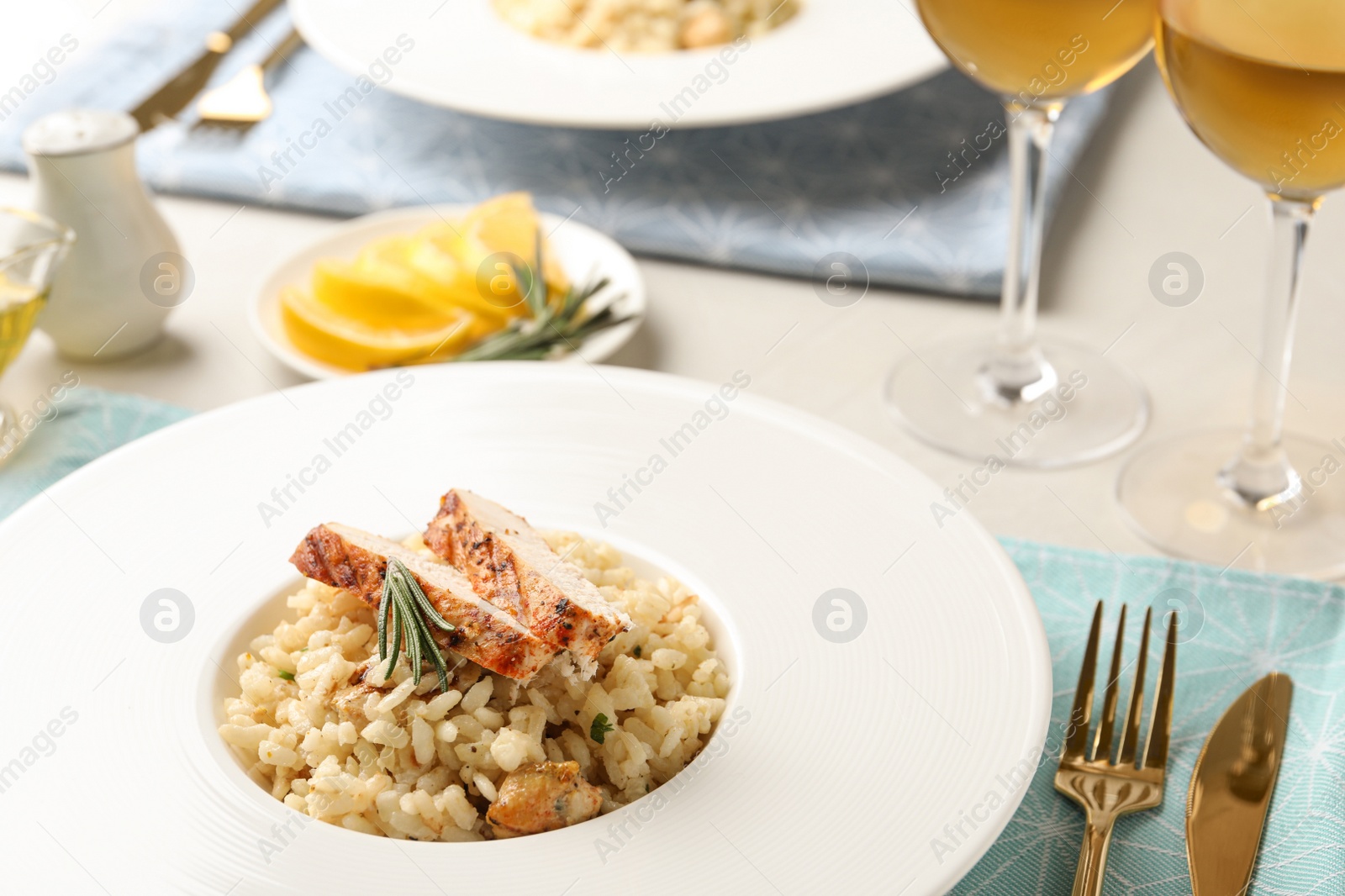 Photo of Delicious chicken risotto with rosemary served on table