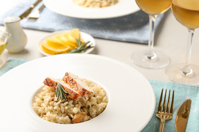 Photo of Delicious chicken risotto with rosemary served on table