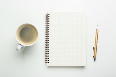 Notebook, coffee and pen on white table, flat lay. Space for text