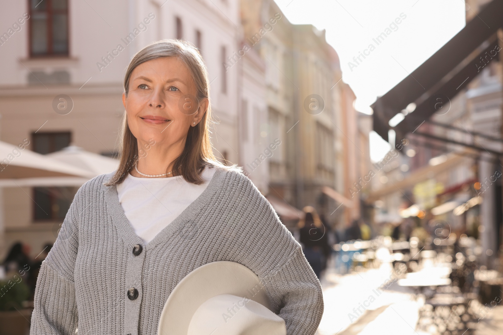 Photo of Beautiful senior woman walking outdoors, space for text