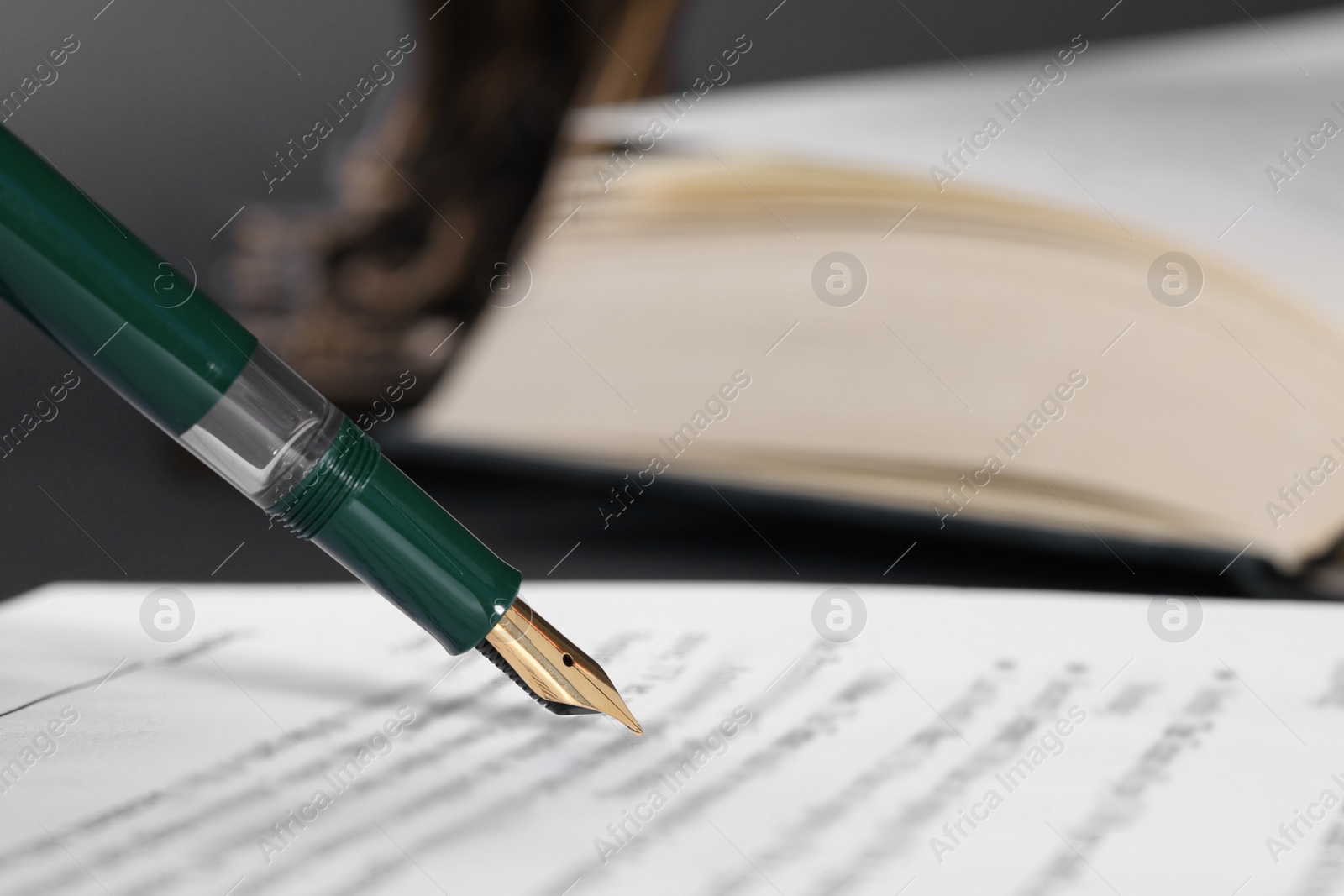 Photo of Writing on document with fountain pen at table, closeup and space for text. Notary contract