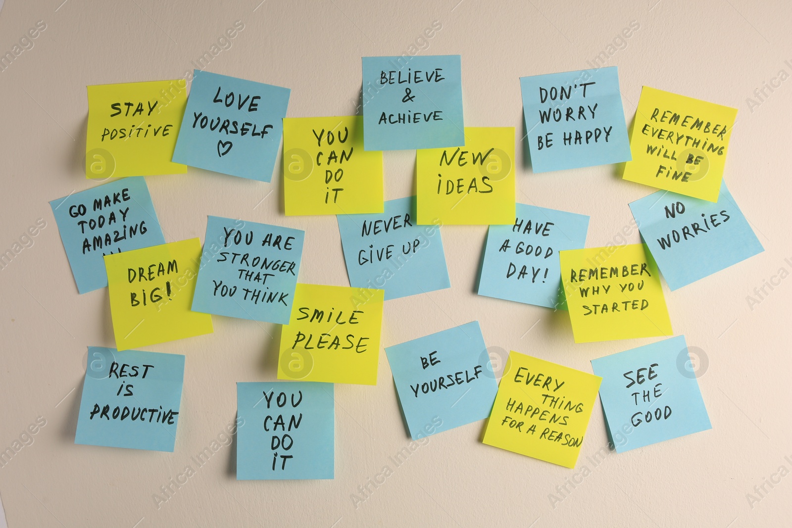 Photo of Paper notes with life-affirming phrases on white wall