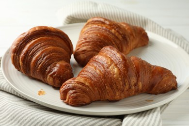 Photo of Plate with tasty croissants on white table, closeup