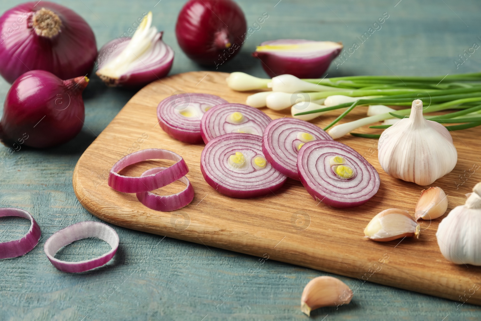 Photo of Composition with cut red onion on light blue wooden table