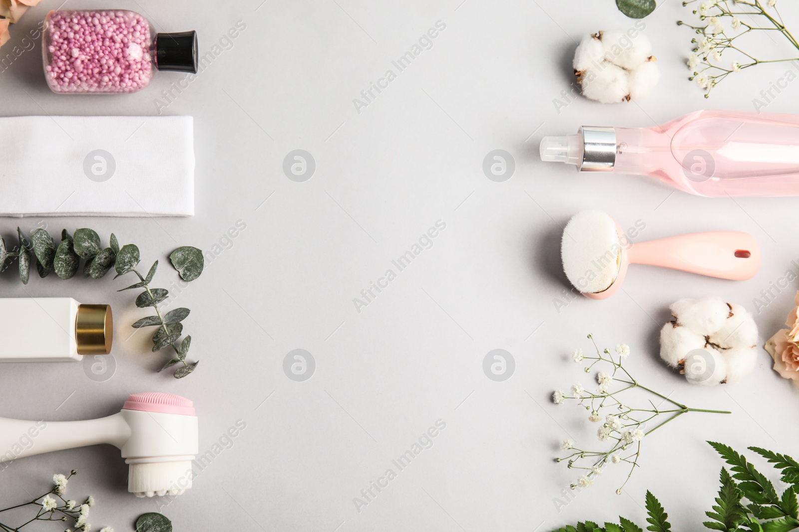 Photo of Flat lay composition with face cleansing brushes on light grey background. Cosmetic accessories