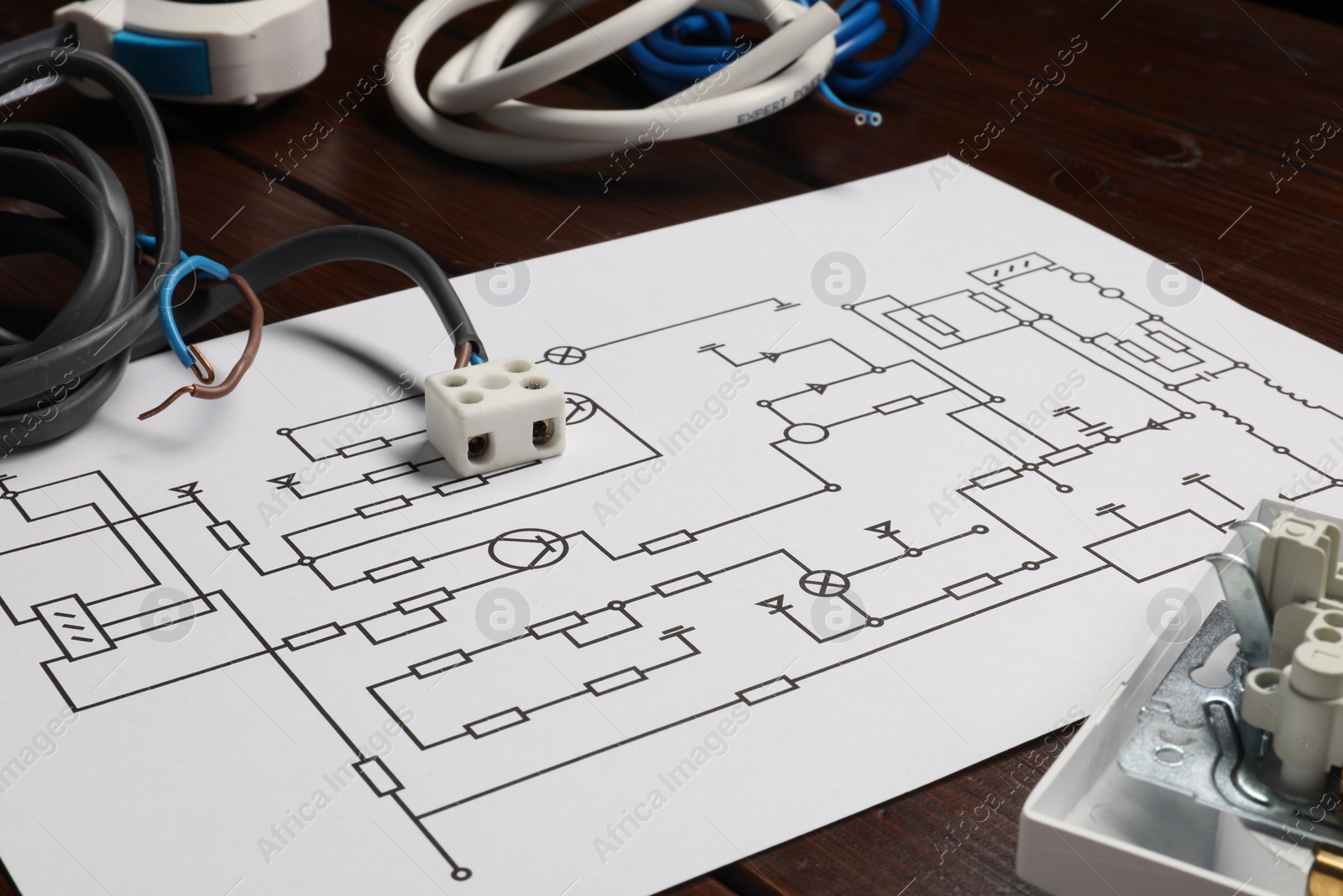 Photo of Wiring diagram, wires and disassembled light switch on wooden table, closeup