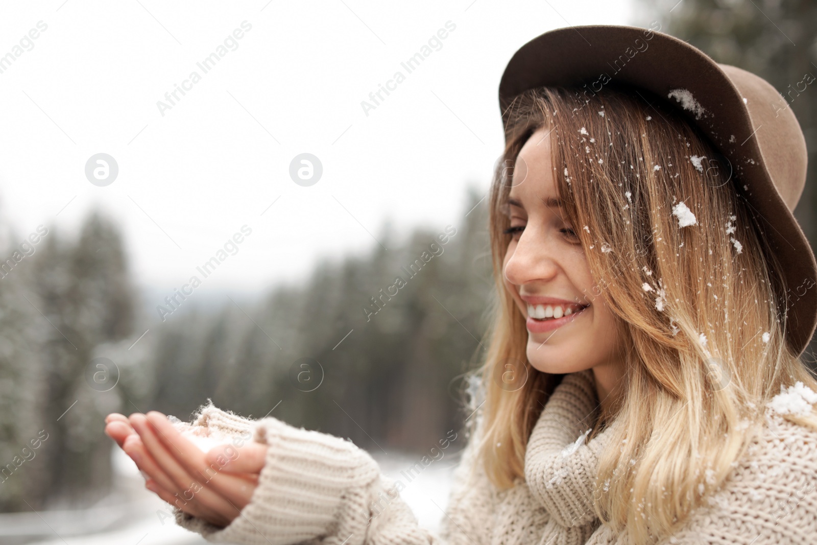 Photo of Young woman playing with snow outdoors. Winter vacation