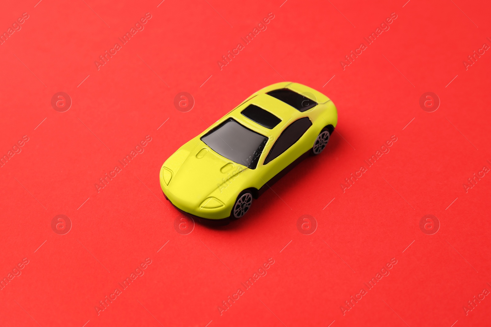 Photo of One yellow car on red background. Children`s toy