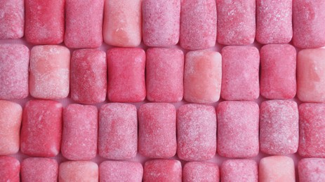 Photo of Many pink chewing gums as background, top view