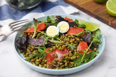 Photo of Plate of salad with mung beans on white marble table, closeup