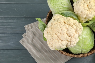 Photo of Bowl with cabbages on wooden table, top view