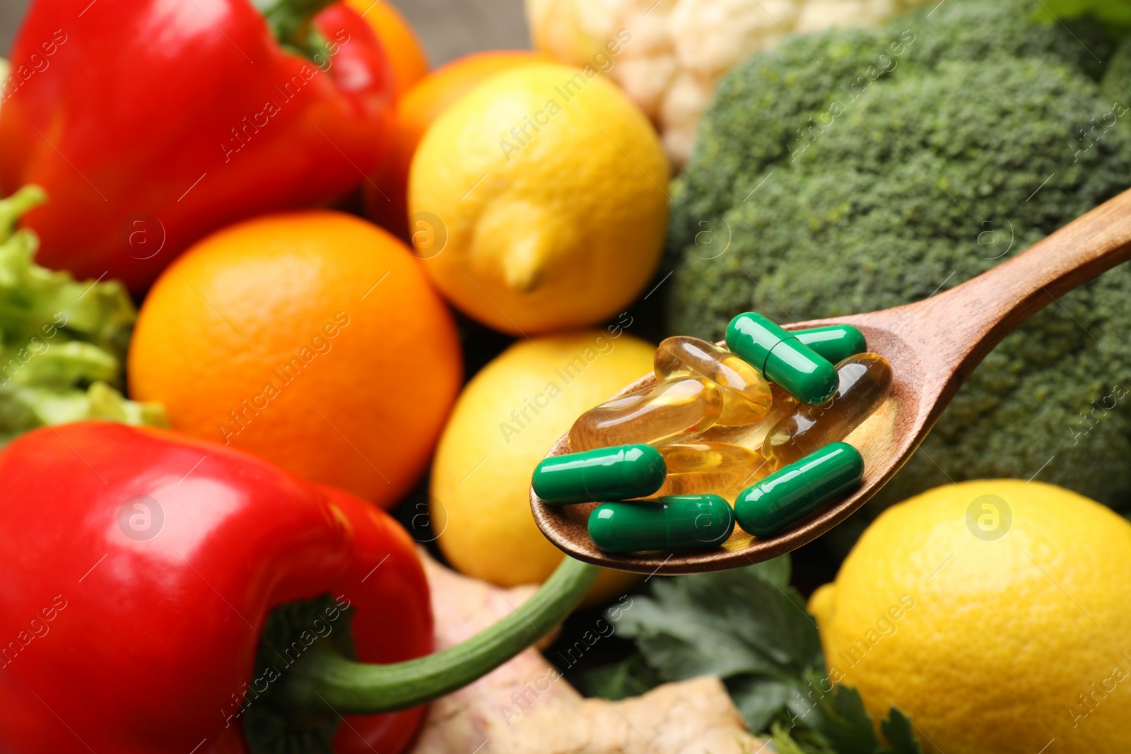 Photo of Dietary supplements. Spoon with pills over food products, closeup