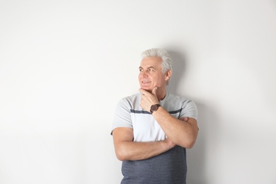 Portrait of handsome mature man on light background. Space for text