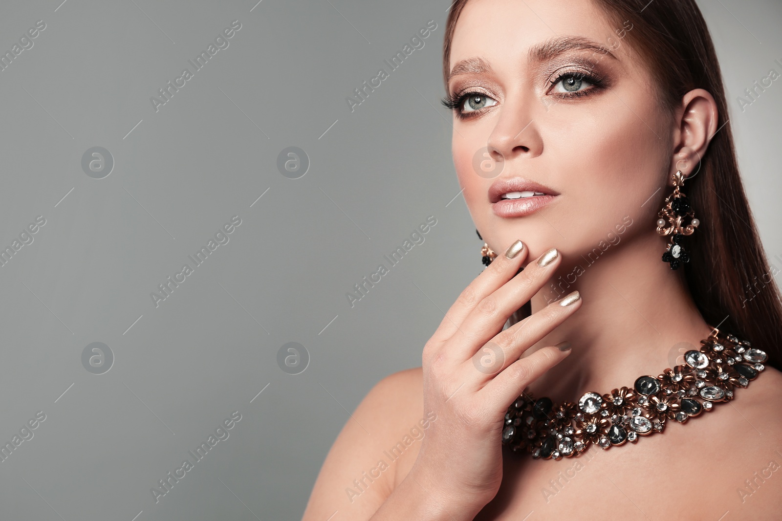 Photo of Beautiful woman with stylish jewelry on grey background, space for text