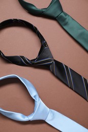 Photo of Three necktie on brown background, flat lay