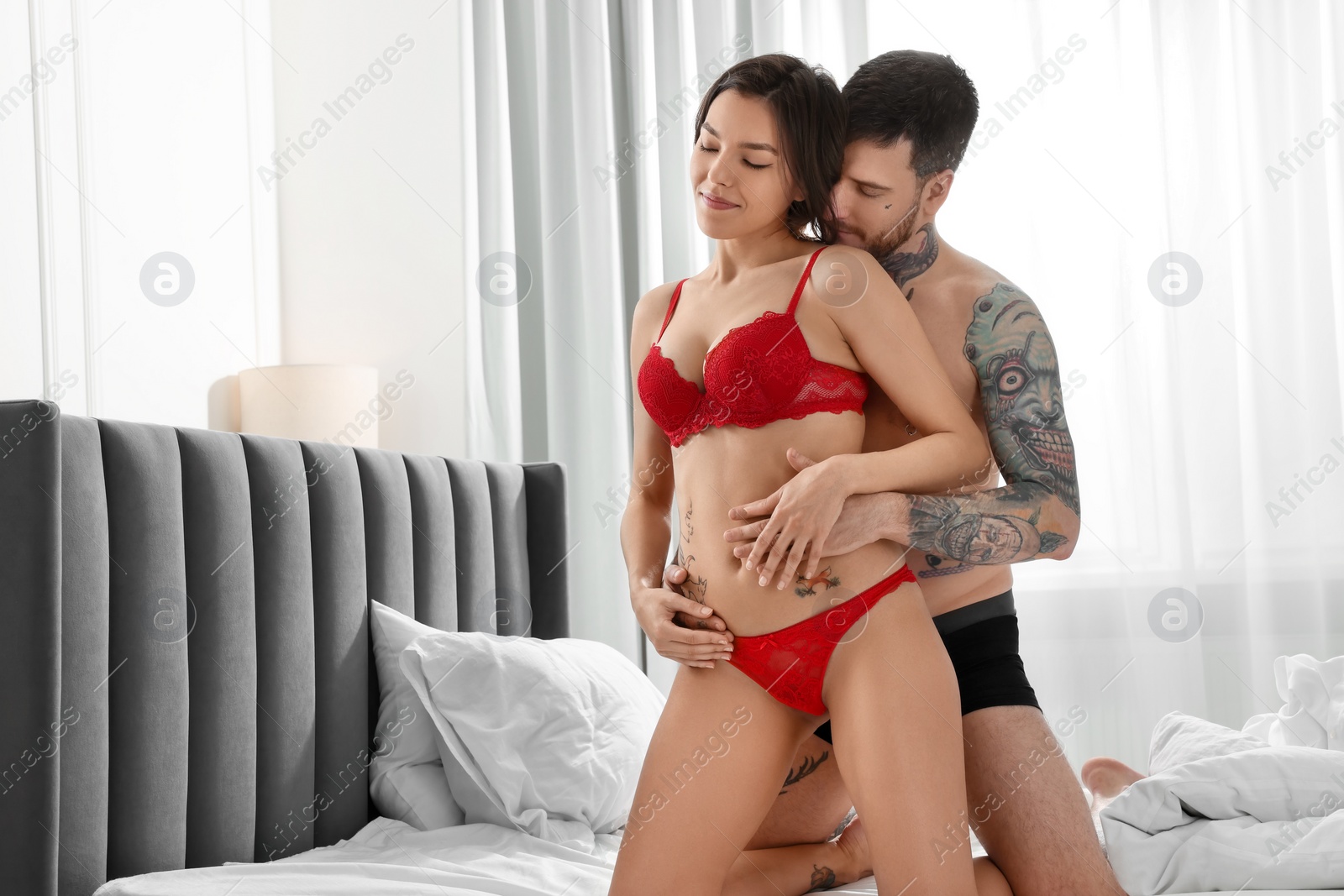 Photo of Passionate couple having sex on bed at home