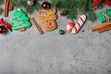 Decorated Christmas cookies on grey table, flat lay. Space for text