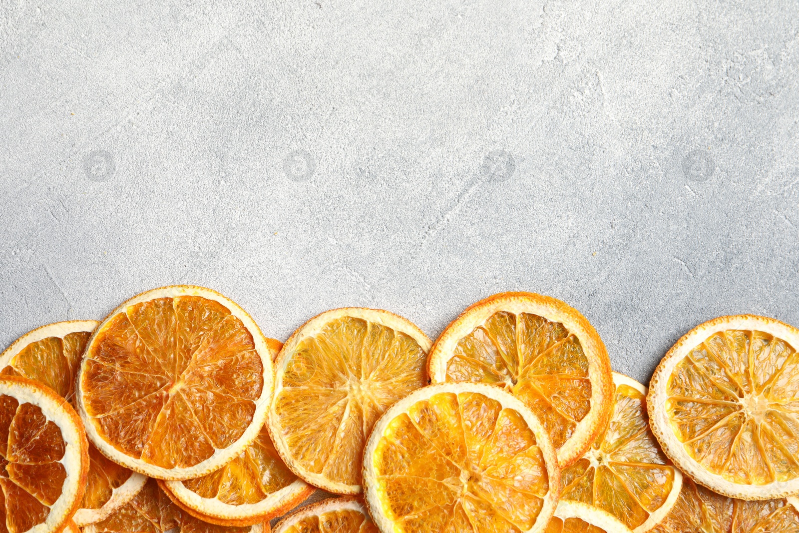 Photo of Dry orange slices on light grey table, flat lay. Space for text