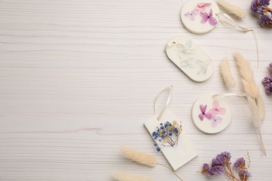 Flat lay composition with scented sachets on white wooden table, space for text