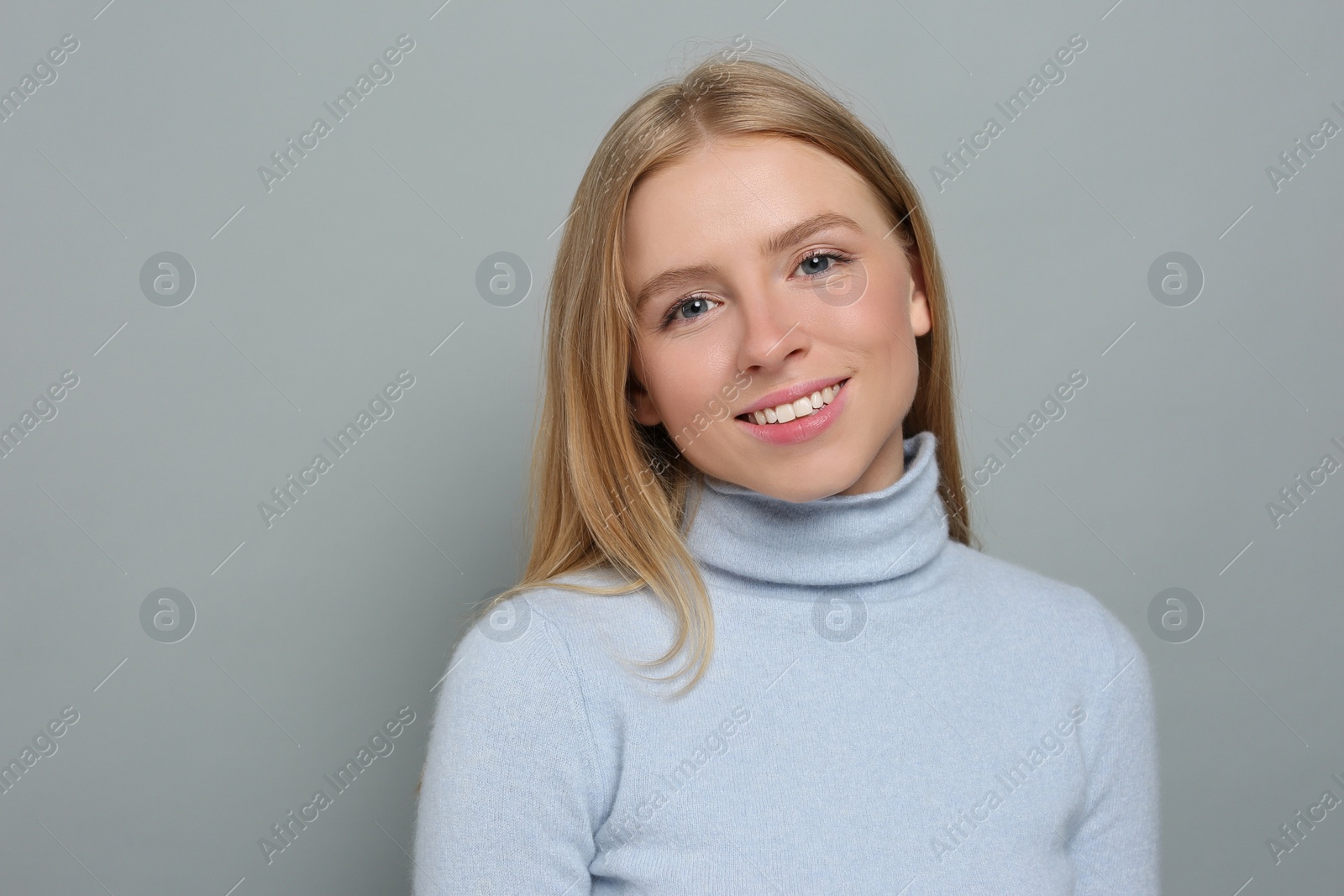 Photo of Portrait of beautiful young woman on grey background