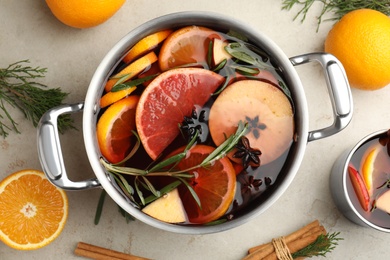 Photo of Tasty mulled wine with spices on light table, flat lay